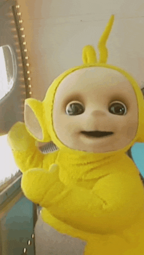 a close up of a yellow teletubbies doll giving a thumbs up