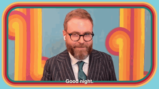 a man with a beard wearing glasses and a suit says good night