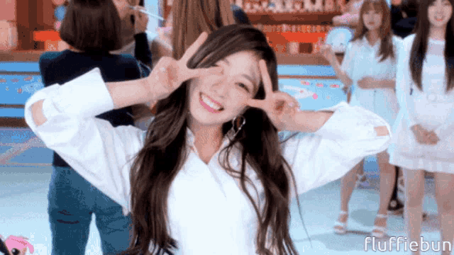 a girl making a peace sign with her hands in front of her face