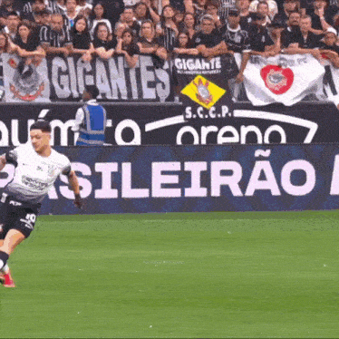 a soccer player kicks the ball in front of a banner that says gigantes s.c.c.p.
