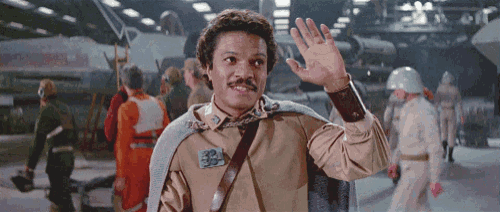 a man wearing a cape with the number 33 on it waves his hand