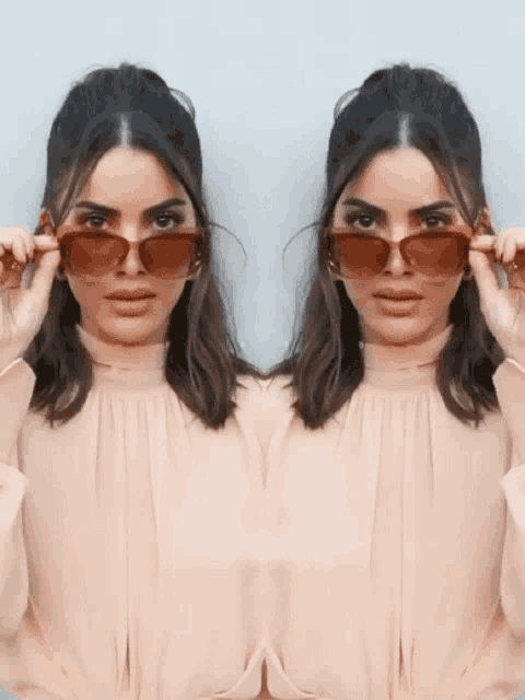 a woman adjusts her sunglasses in front of her face