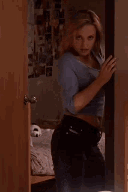 a woman is standing in a doorway with her arm outstretched