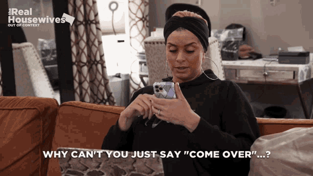 a woman sitting on a couch looking at her phone with the words why can 't you just say " come over "