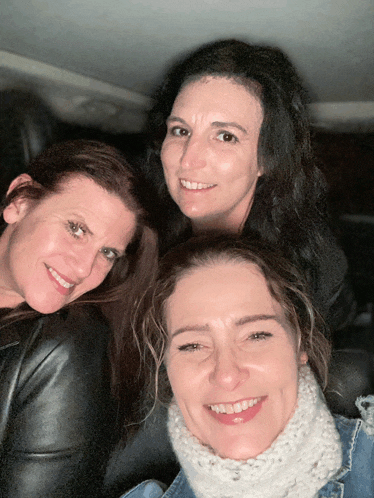 three women are posing for a picture and smiling
