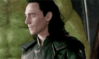 loki from avengers : age of ultron is wearing a green suit and smiling .