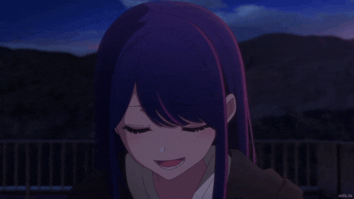 a girl with purple hair and pink eyes is smiling in a dark room