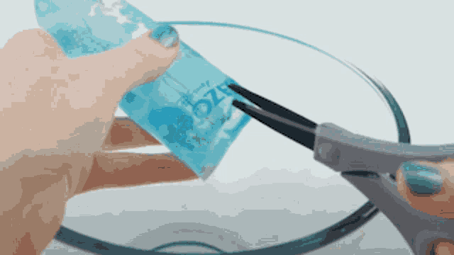 a person is cutting a disney frozen bottle with scissors