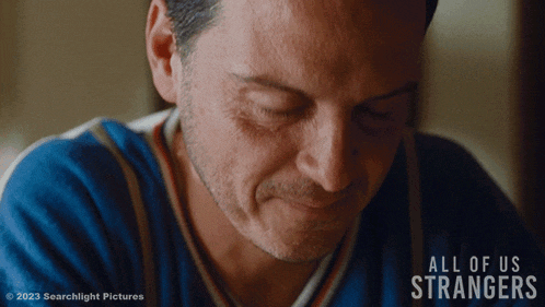 a close up of a man 's face with the words all of us strangers in the corner