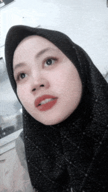 a woman wearing a black scarf and a black hijab