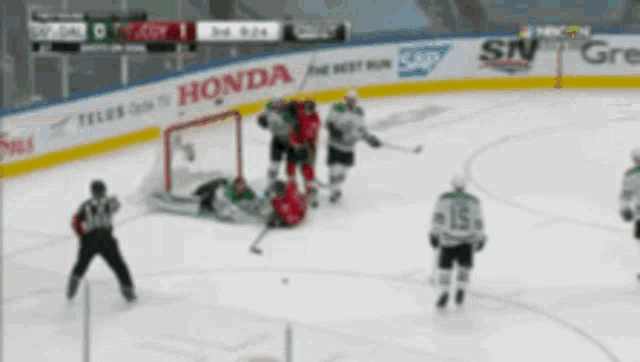 a hockey game is being played on a rink with a honda banner on the fence