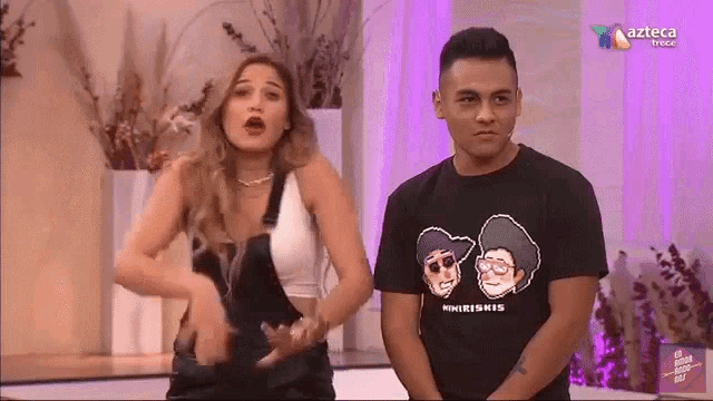 a man and a woman are standing next to each other in a room .