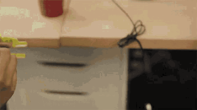 a person is measuring something with a tape measure while sitting at a desk .