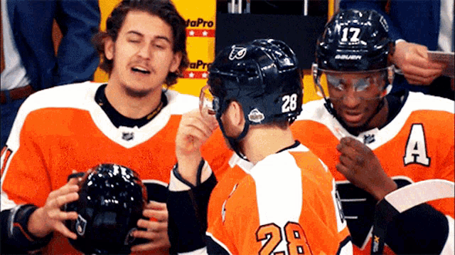 a hockey player wearing number 28 talks to another player