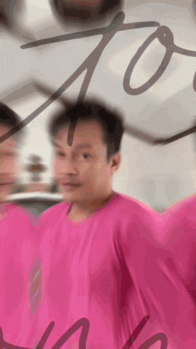 a man in a pink shirt is standing in front of a sign that says 70