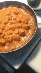 a frying pan filled with a red sauce and meat