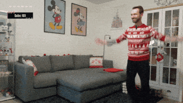 a man in a red and white sweater is dancing in a living room