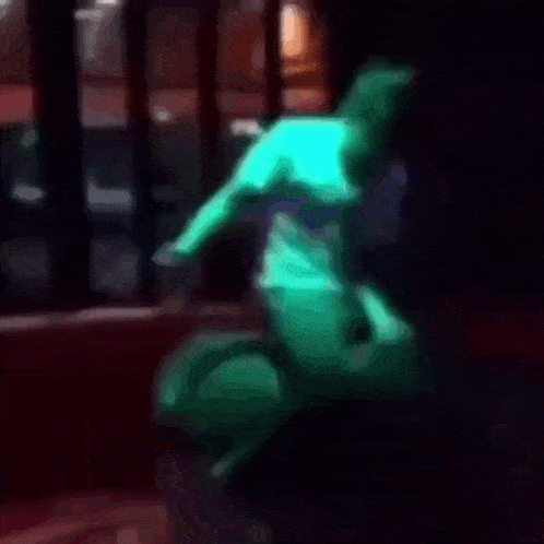 a blurry picture of a person sitting in a chair with a green light behind them