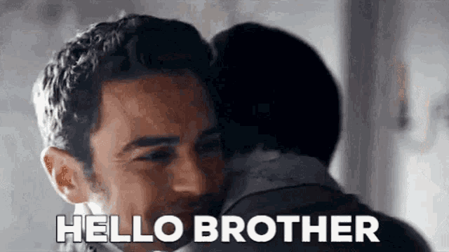 a man is hugging another man and saying hello brother .