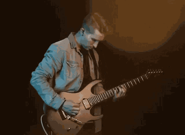 a man is playing an electric guitar in a dark room in a dark room .