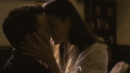 a man and a woman are kissing in the dark