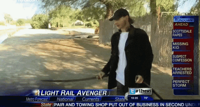 a man is holding a sword in front of a news screen that says " light rail avenger "