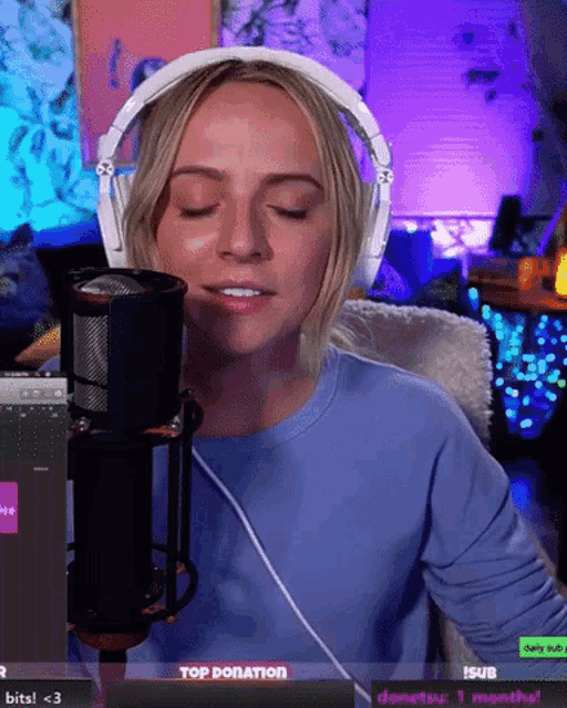 a woman wearing headphones stands in front of a microphone with the words top donation on the screen behind her