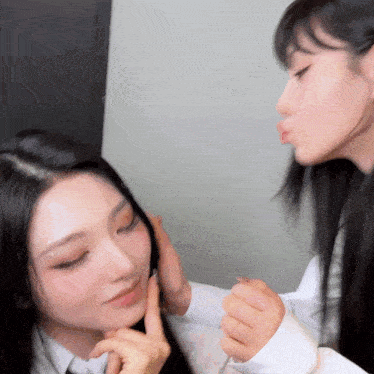 two women are kissing each other on the cheek