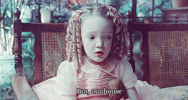 a little girl in a pink dress is sitting in a chair with the words " but our house " written below her