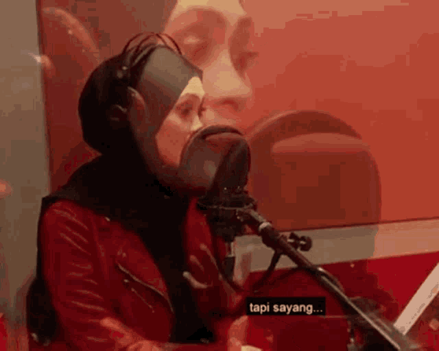 a woman singing into a microphone with the words tapi sayang written below her