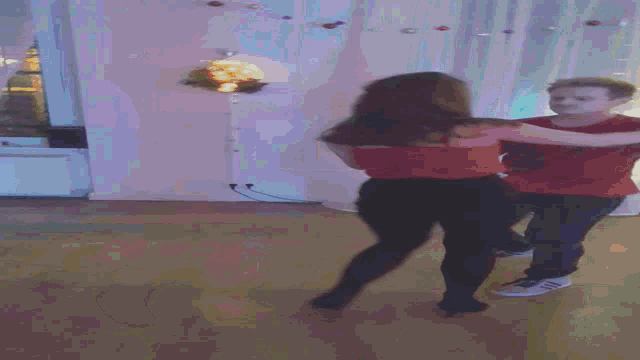 a man and woman are dancing in a room with christmas decorations