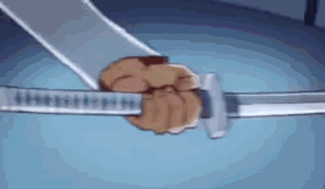 a close up of a person holding a sword in their fist .