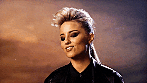 a woman wearing a black leather jacket and a black shirt is smiling