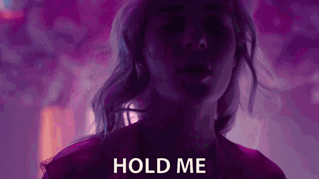 a close up of a woman 's face with the words `` hold me '' written on the bottom .