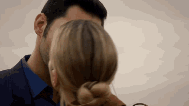 a man in a suit kisses a woman on the cheek