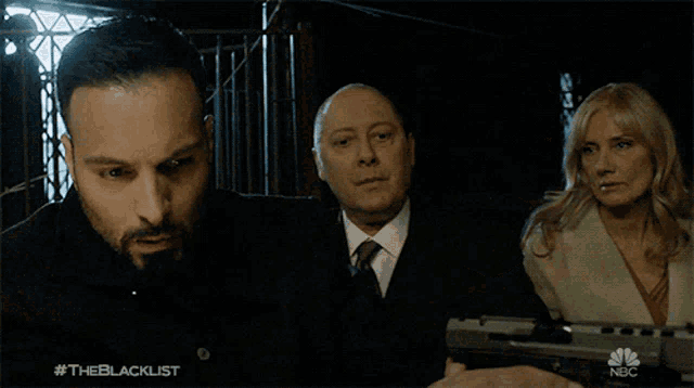 a group of people looking at a gun with the blacklist written in the corner