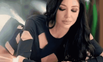 a woman in a black dress is laying on her stomach on a bed .