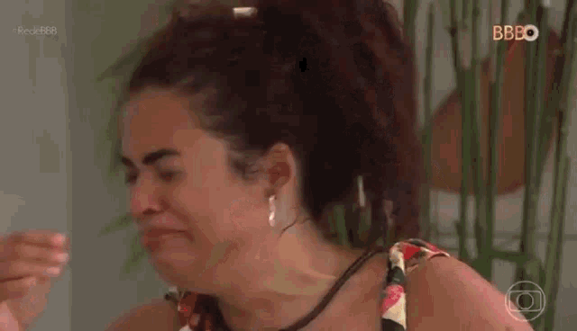 a woman is covering her face with her hand while crying .