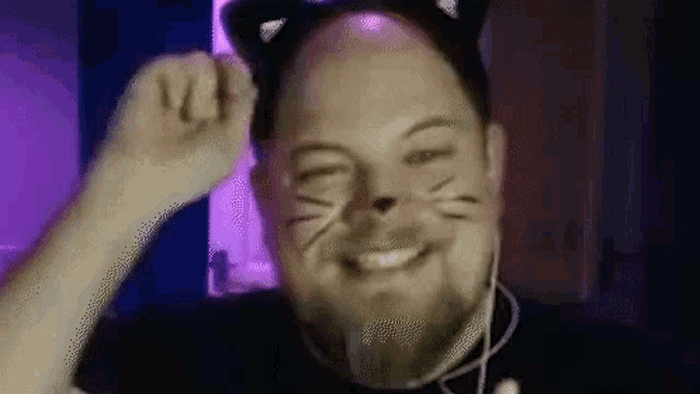 a man with a cat face painted on his face is wearing a cat ear headband .