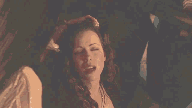 a woman with vampire teeth is surrounded by other women