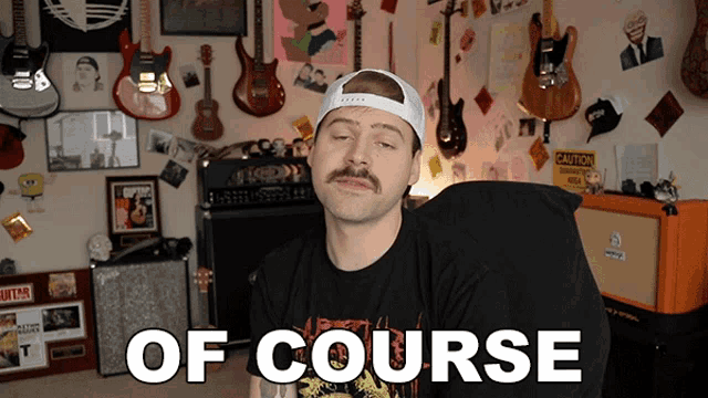 a man with a mustache is sitting in front of a wall of guitars and a sign that says " of course "
