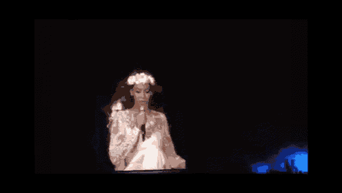 a woman singing into a microphone on a stage