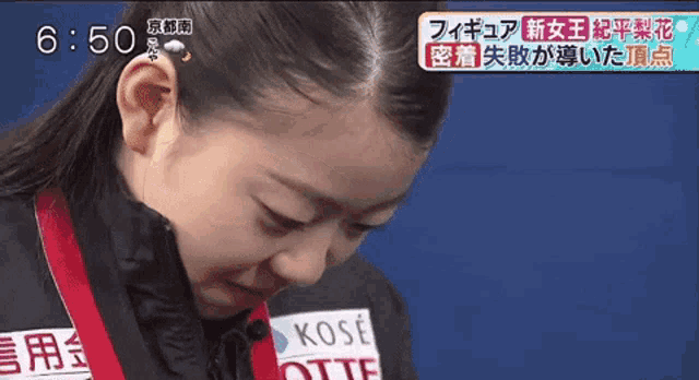 a close up of a woman 's face with a medal around her neck that says kose