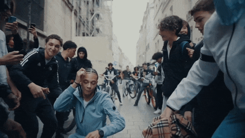 a man in a blue jacket is surrounded by people