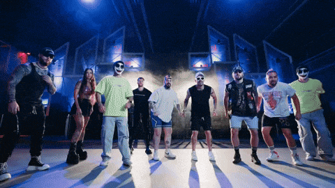 a group of people wearing masks are standing on a stage