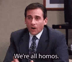 a man in a suit and tie is sitting at a desk and saying `` we 're all homos '' .