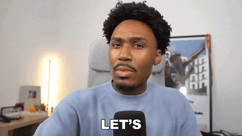a man is holding a microphone and saying let 's