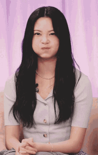 a woman with long black hair is making a face