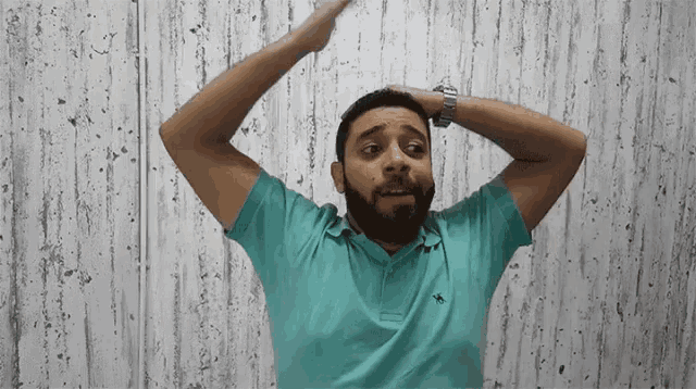 a man with a beard is wearing a blue polo shirt with a bird on it
