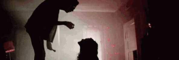 a man is standing next to a woman in a dark room with red lights .
